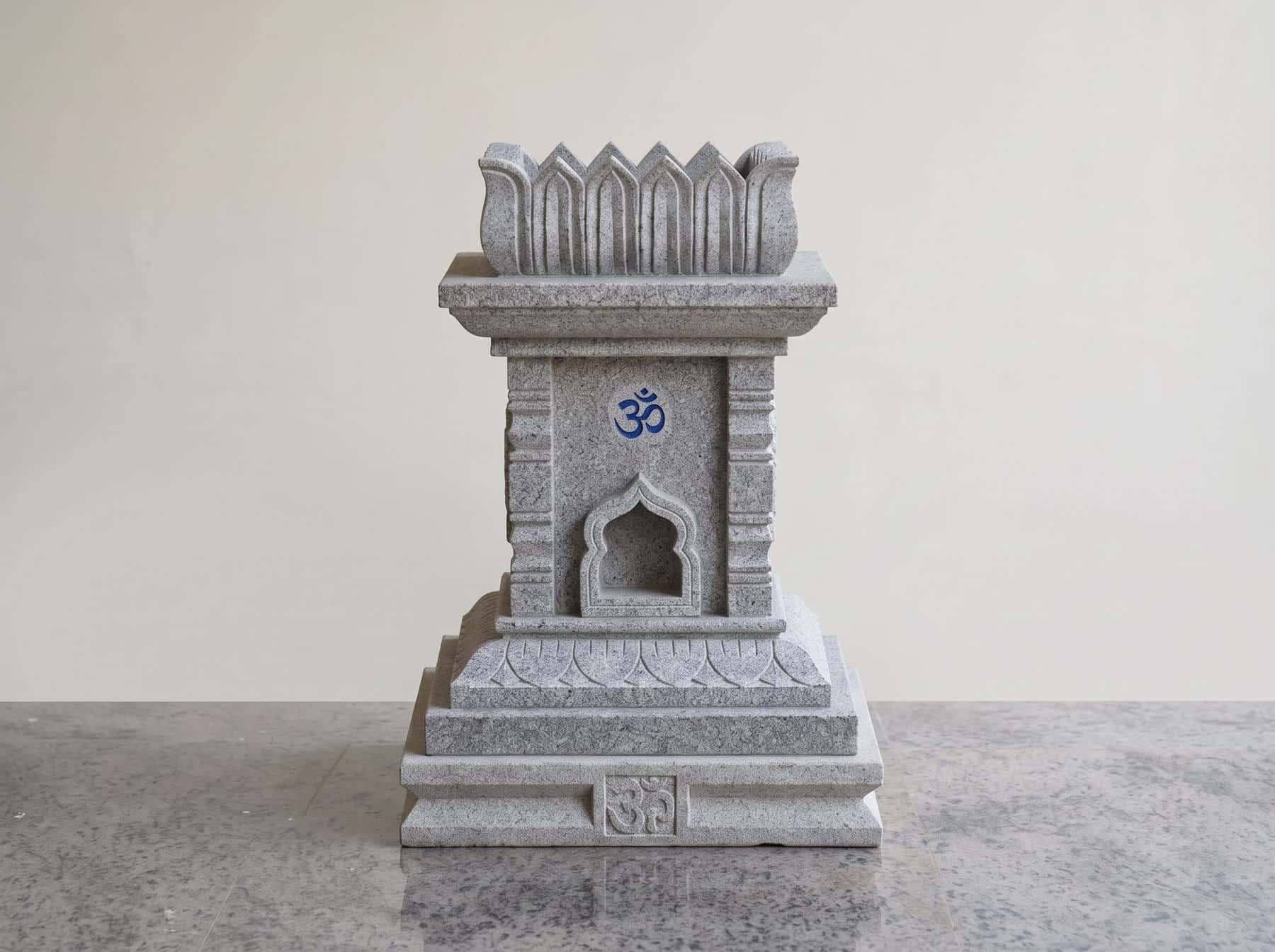 Grey granite tulsi katte with an Om carving and arched lamp niche